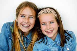 Happy young sisters with braces