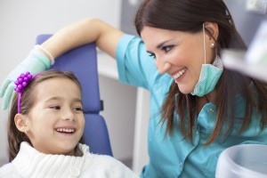 Female hygienist and young girl smiling