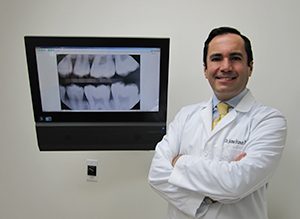 Male dentist standing in front of digital x-ray