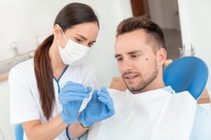 dental assistant showing patient invisalign aligner