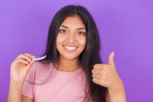 girl holding invisalign aligner